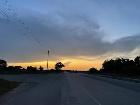 Dramatic Storm Cloud Over Rural Texas Highway at Twilight Stock Photos