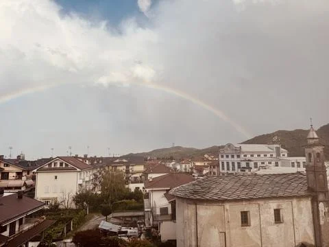 Dramatic storm clouds and rainbow over town. Foto stock