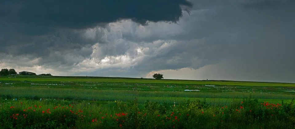 Dramatic storm clouds and sky from a strong thunderstorm in a summer field wi Stock Photos