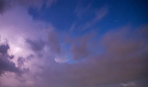 Dramatic storm clouds with blue sky, stars and lightening bolt Stock Photos