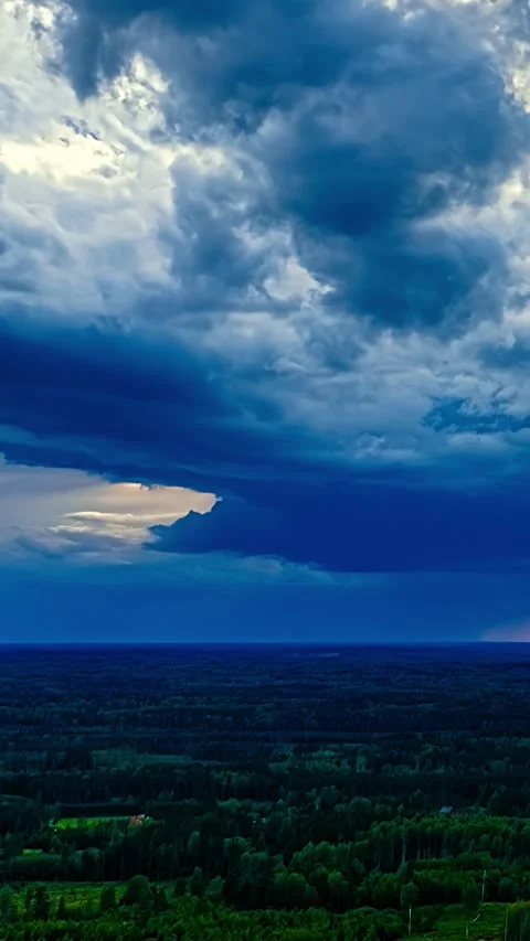 Dramatic Storm Clouds Break With Sunbeams Over Forest Landscape Vertical Stock Footage 343008373