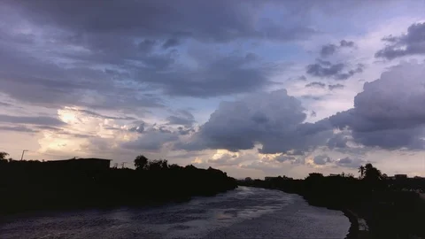 Dramatic storm clouds building above River in town at Thailand in Asia Stock Footage 108989179