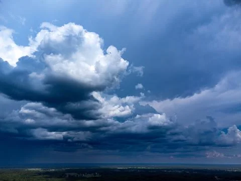 Dramatic storm clouds cast shadows over rural landscape. Stock Photos