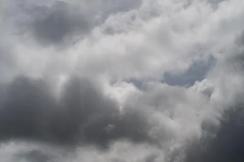 Dramatic storm clouds fill brooding sky, heavy cumulus layers rolling across  Stock Photos