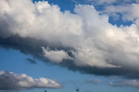 Dramatic storm clouds gather across a bright blue sky Stock Photos