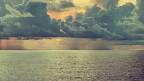 Dramatic storm clouds gather over a vast ocean at sunset creating a vivid a.. Stock Footage 338282188