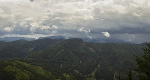 Dramatic Storm Clouds Gathering Above Vast Forested Mountain Ridges and Rem.. Stock-Fotos