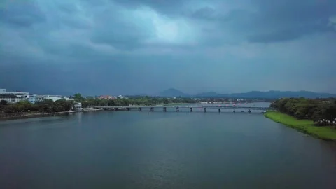 Dramatic storm clouds gathering over a river bridge in hue, vietnam Stock Footage 329509077
