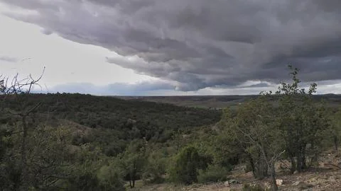 Dramatic Storm Clouds Gathering Over Forested Valley Landscape Stock Photos