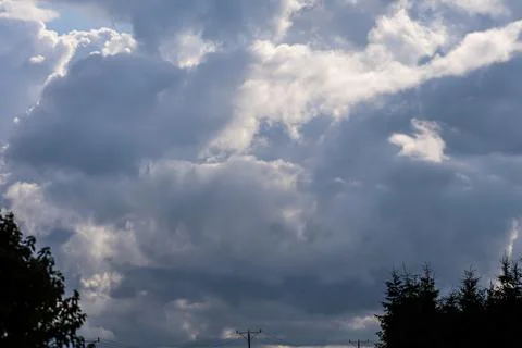 Dramatic storm clouds gathering overhead with hints of sunlight breaking th.. 写真素材