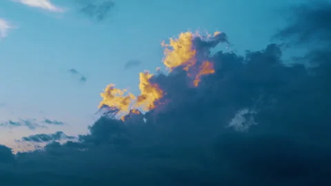 Dramatic storm clouds illuminated by the setting sun. Golden sunlight breaks Stock Footage 338316538
