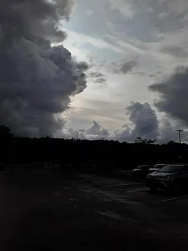 Dramatic Storm Clouds Looming Over a Darkened Parking Lot Stock Photos