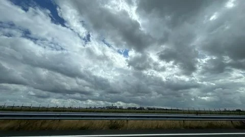 Dramatic storm clouds over airport perimeter with runway, control tower Stock Photos