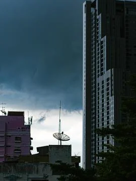 Dramatic Storm Clouds Over Bangkok Skyline with Satellite Dish and High-Ris.. Foto stock