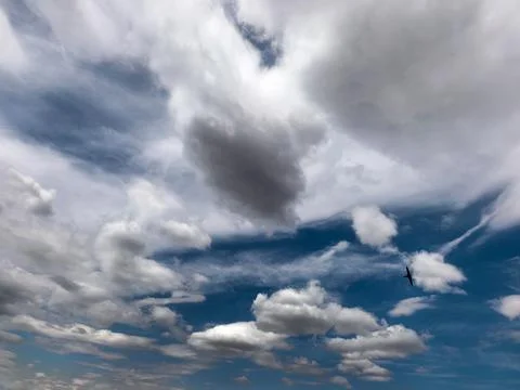 Dramatic Storm Clouds Over Blue Summer Sky with Flying Bird Stock Photos