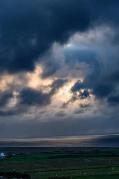 Dramatic storm clouds over coastal hills and ocean, dark sky and moody nature la Stock Photos