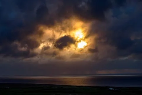 Dramatic storm clouds over coastal hills and ocean, dark sky and moody nature la Stock Photos