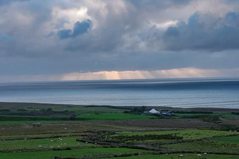 Dramatic storm clouds over coastal hills and ocean, dark sky and moody nature la Stock Photos