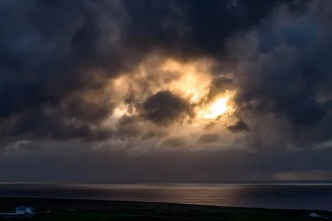 Dramatic storm clouds over coastal hills and ocean, dark sky and moody nature la Stock Photos