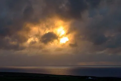 Dramatic storm clouds over coastal hills and ocean, dark sky and moody nature la Stock Photos