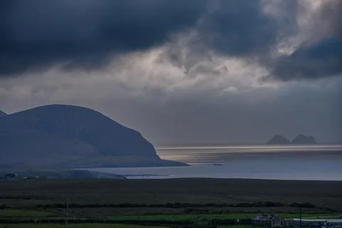 Dramatic storm clouds over coastal hills and ocean, dark sky and moody nature la Stock Photos