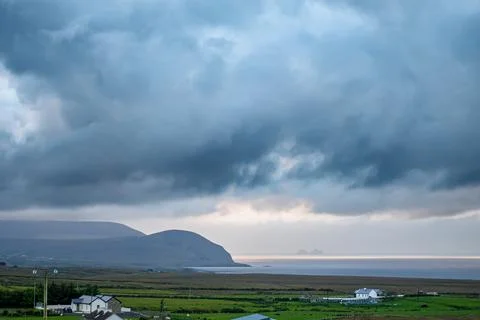 Dramatic storm clouds over coastal hills and ocean, dark sky and moody nature la Stock Photos