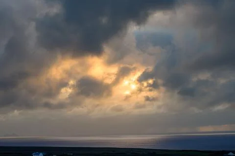 Dramatic storm clouds over coastal hills and ocean, dark sky and moody nature la Stock Photos
