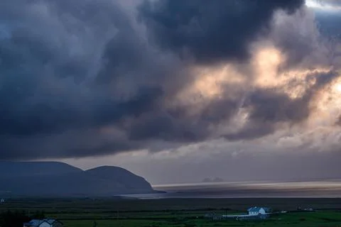 Dramatic storm clouds over coastal hills and ocean, dark sky and moody nature la Stock Photos