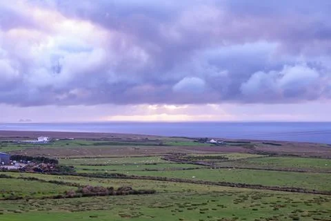 Dramatic storm clouds over coastal hills and ocean, dark sky and moody nature la Stock Photos