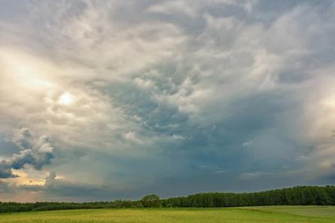 Dramatic storm clouds over green countryside landscape before rain Photos