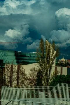 Dramatic Storm Clouds over Modern City Church and Architecture Stock Photos