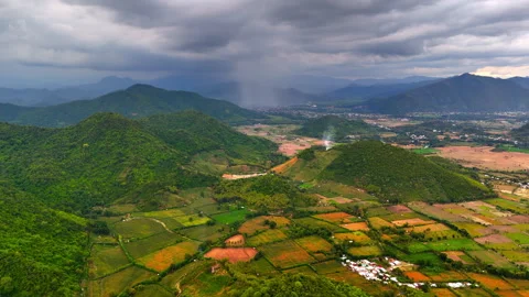 Dramatic storm clouds over mountain valley and patchwork farmlands aerial drone Stock Footage 328970570