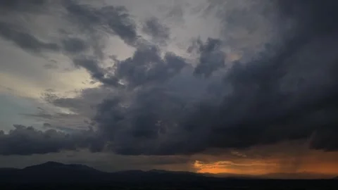 Dramatic storm clouds over a rural landscape at sunset Video stock 335668979