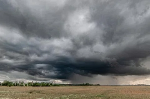 Dramatic Storm Clouds Over a Rural Landscape With a Dirt Road Stock Photos