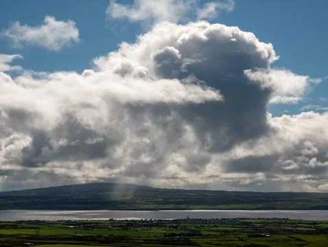 Dramatic storm clouds over rural landscape and water Foto stock