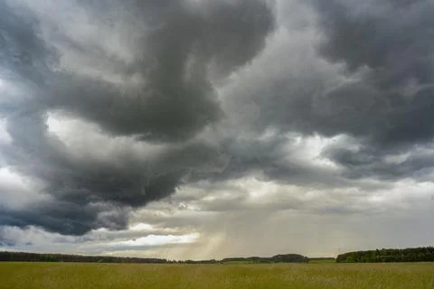 Dramatic Storm Clouds Over Rural Field with Rain in Distance 写真素材