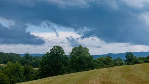 Dramatic storm clouds over rural summer landscape 库存照片