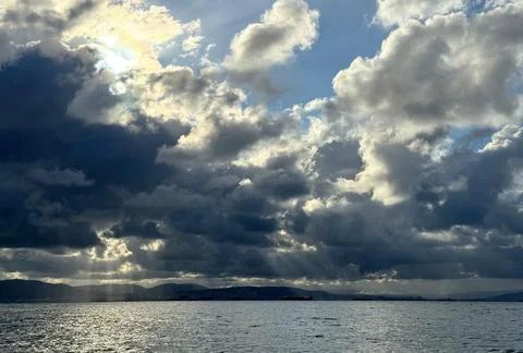 Dramatic Storm Clouds Over the Sea With Sun Rays 库存照片