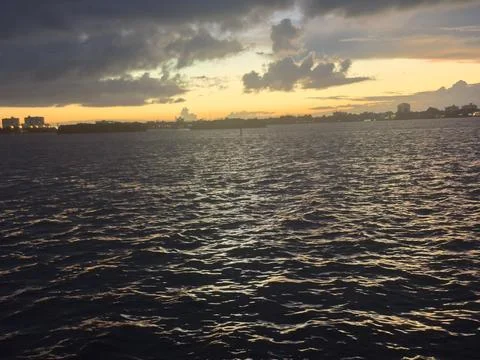 Dramatic Storm Clouds Over Waterfront at Sunset Stock Photos