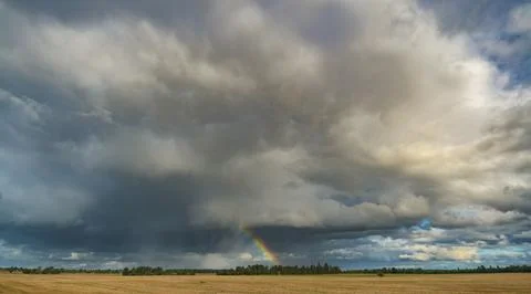 Dramatic storm clouds with a rainbow Stock Photos
