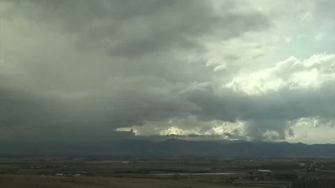 Dramatic storm clouds rolling in over mountains and landscape Video stock 74088573
