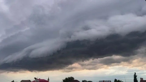 Dramatic storm clouds rolling over town horizon with intense sky Video stock 315671402