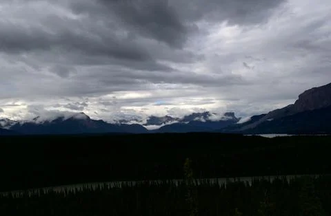 Dramatic Storm Clouds Rolling Over Majestic Mountain Range Stock Photos