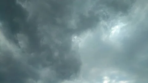 Dramatic storm clouds rolling past to show patches of blue sky hidden Stock Footage 111735370