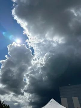 Dramatic Storm Clouds with Sun Breaking Through Over Urban Skyline Stock Photos