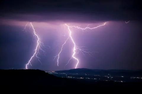 Dramatic storm with lightning above city at night Stock Photos