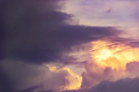 Dramatic stormy clouds with bright golden sunset glow and dark copy space Stock Photos