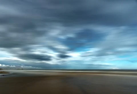 Dramatic stormy clouds over beach with coastal buildings and sea Fotos de archivo