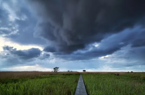 Dramatic stormy clouds over pier path Foto stock