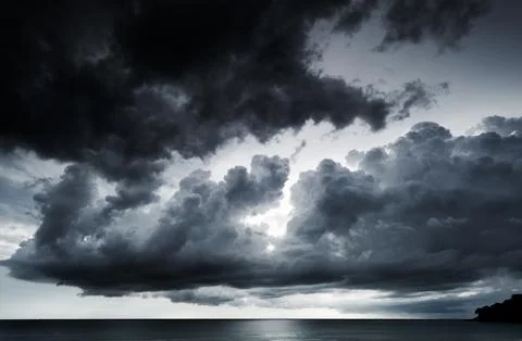 Dramatic stormy dark cloudy sky over sea in bad weather day Raining clouds .. Stock Photos